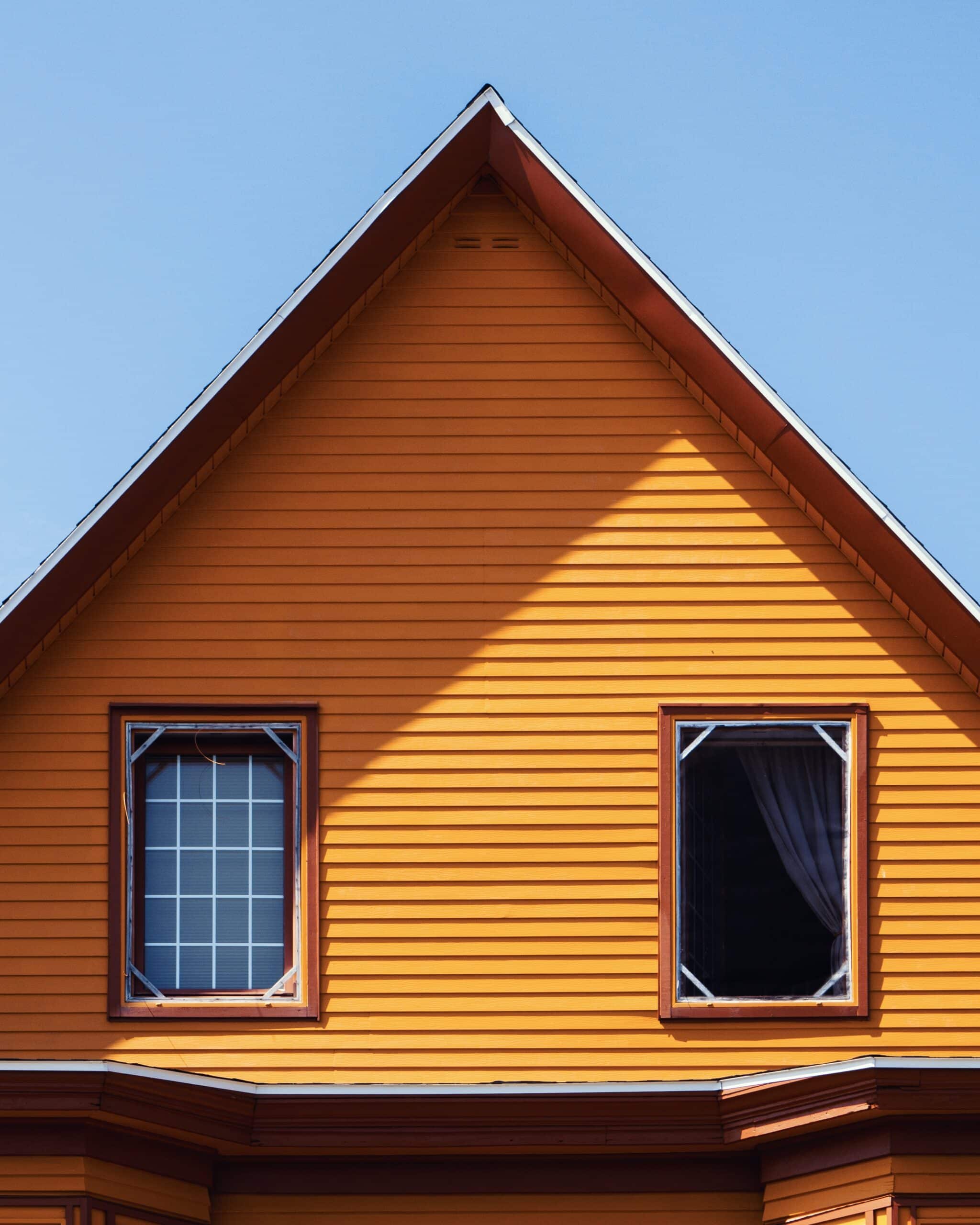 Vertical shot of a wooden orange house under the clear blue sky vertical shot wooden orange house clear blue sky scaled